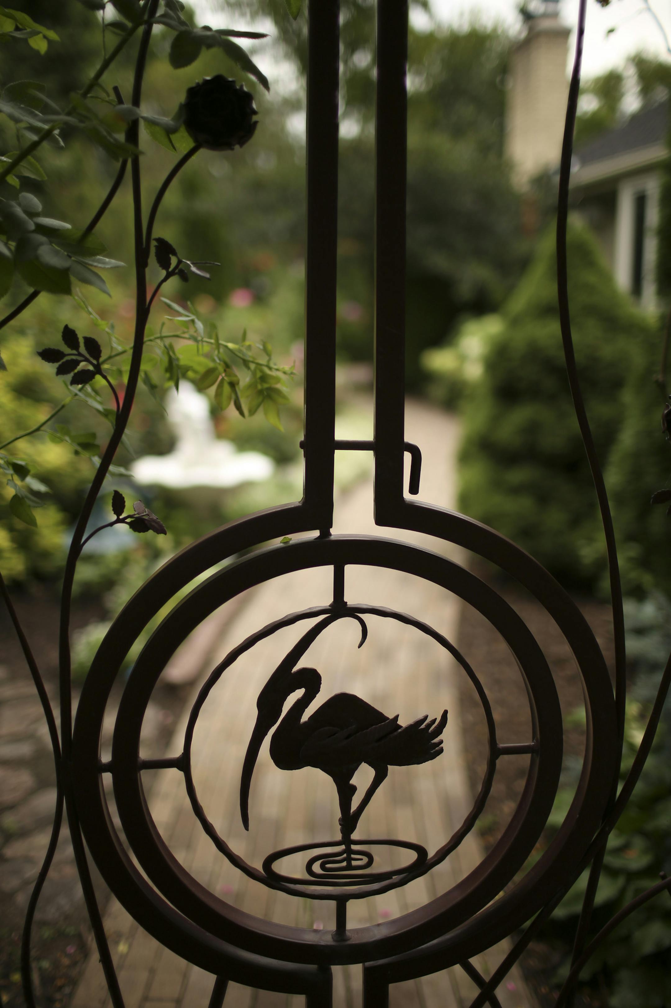 A custom iron gate frames the side garden.