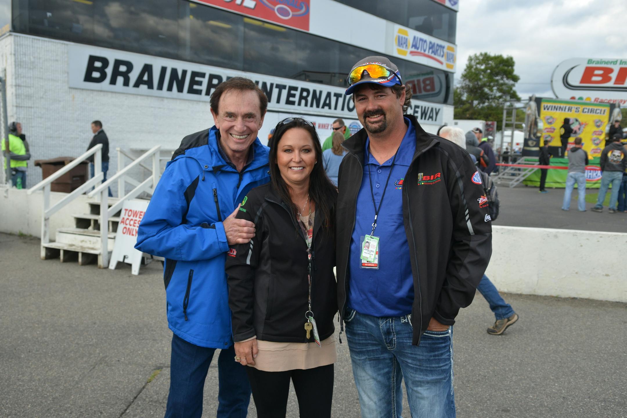 Brainerd International Raceway owner Jed Copham, right, stands with his wife, Kristi, and Forrest Lucas, founder and owner of Lucas Oil Products, during the Lucas Oil NHRA Nationals at BIR last year.