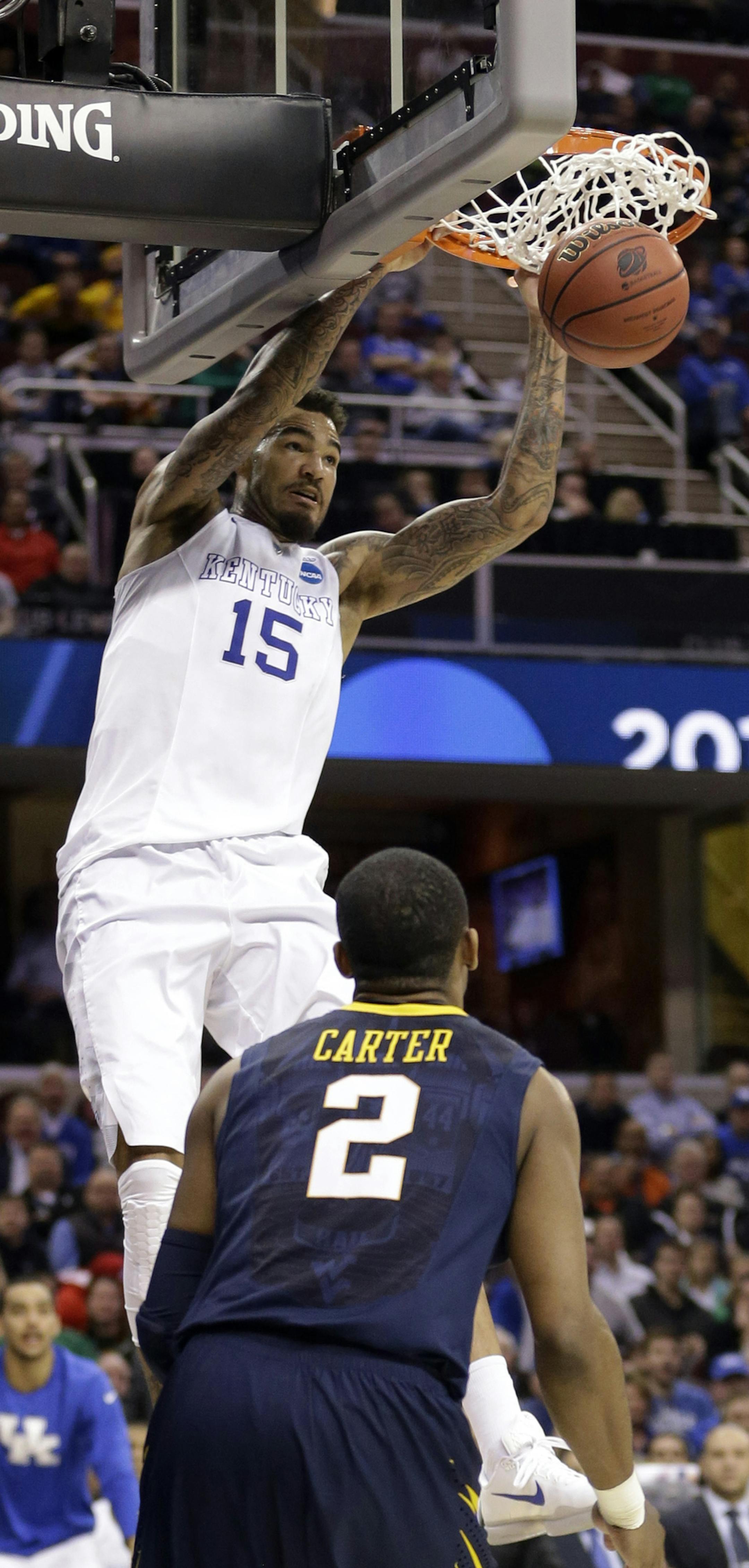 Kentucky's Willie Cauley-Stein (15) dunks on West Virginia's Jevon Carter (2) in the second half of a college basketball game in the NCAA men's tournament regional semifinals, Thursday, March 26, 2015, in Cleveland. (AP Photo/Tony Dejak)