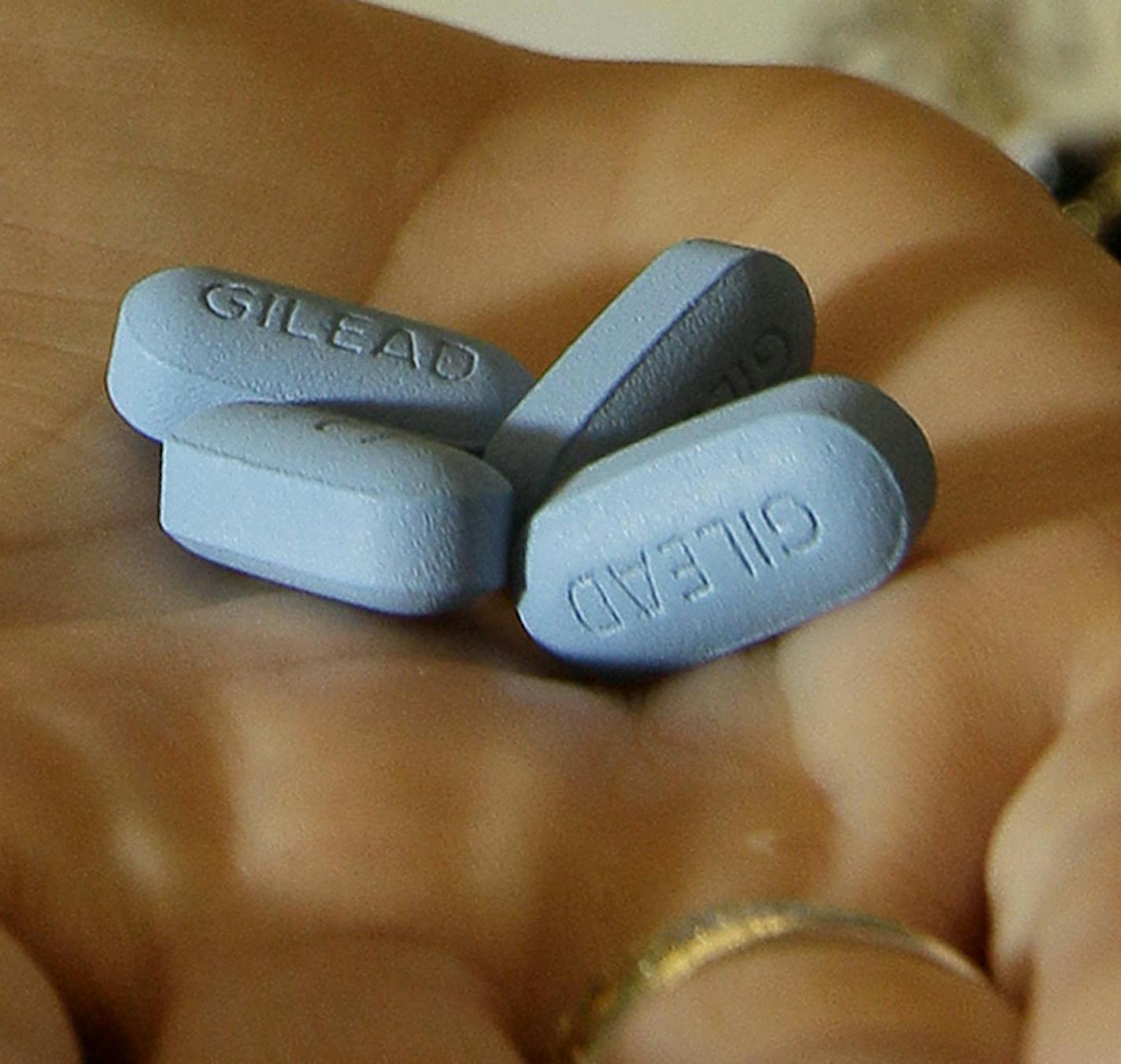 FILE - In this May 10, 2012, file photo, a doctor holds Truvada pills in her office in San Francisco. Studies released on Tuesday, June 11, 2019 show the anti-AIDS treatment also cuts the chances that someone who&#x2019;s still healthy becomes infected from risky sex or injection drug use. But with nearly 40,000 new HIV infections each year in the U.S., only a fraction of people who could benefit are prescribed the drug for prevention. (AP Photo/Jeff Chiu, File)