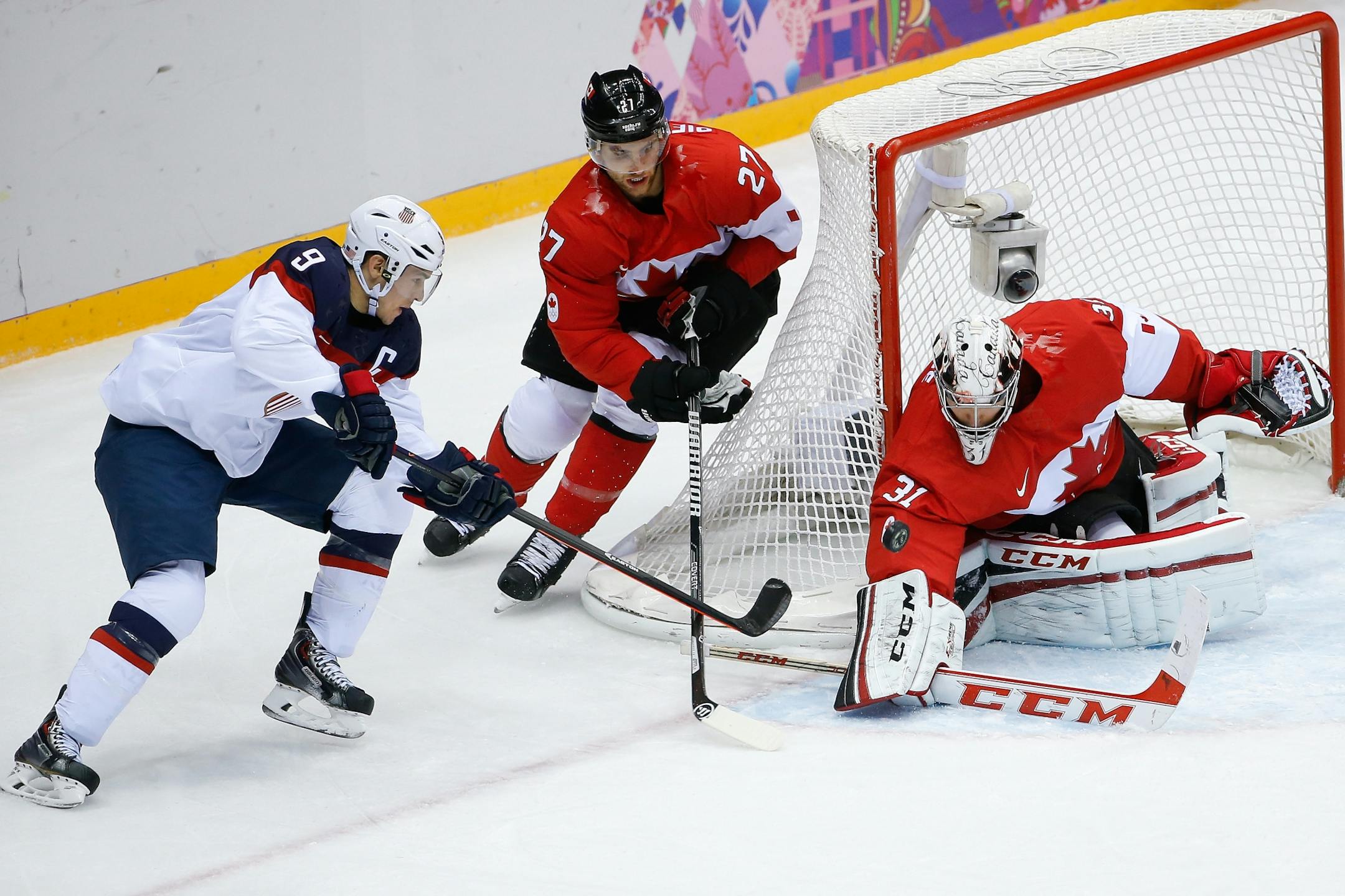 Canada goaltender Carey Price blocks a shot at the goal by USA forward Zach Parise as Canada defenseman Alex Pietrangelo skates into help protect the goal during the men's semifinal ice hockey game at the 2014 Winter Olympics, Friday, Feb. 21, 2014, in Sochi, Russia.
