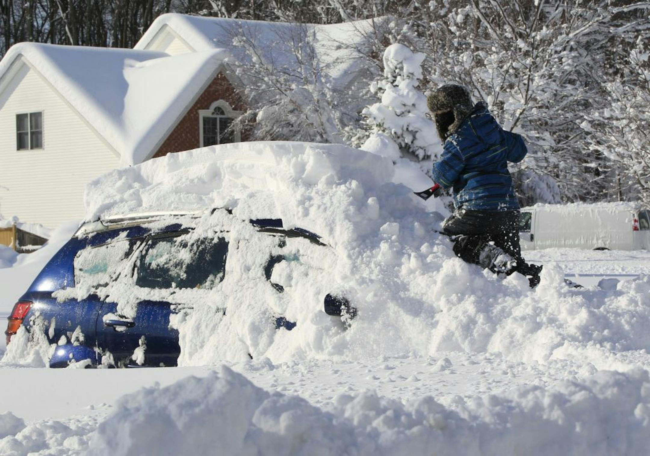 Braeden Attig,11, removes snow from a buried car along Powers Road in Orchard Park, N.Y. on Wednesday, Nov. 19, 2014. A ferocious lake-effect storm left the Buffalo area buried under 6 feet of snow Wednesday, trapping people on highways and in homes, and another storm expected to drop 2 to 3 feet more was on its way. (AP Photo/The Buffalo News, Harry Scull Jr.) TV OUT; MAGS OUT; MANDATORY CREDIT; BATAVIA DAILY NEWS OUT; DUNKIRK OBSERVER OUT; JAMESTOWN POST-JOURNAL OUT; LOCKPORT UNION-SUN JOURNAL