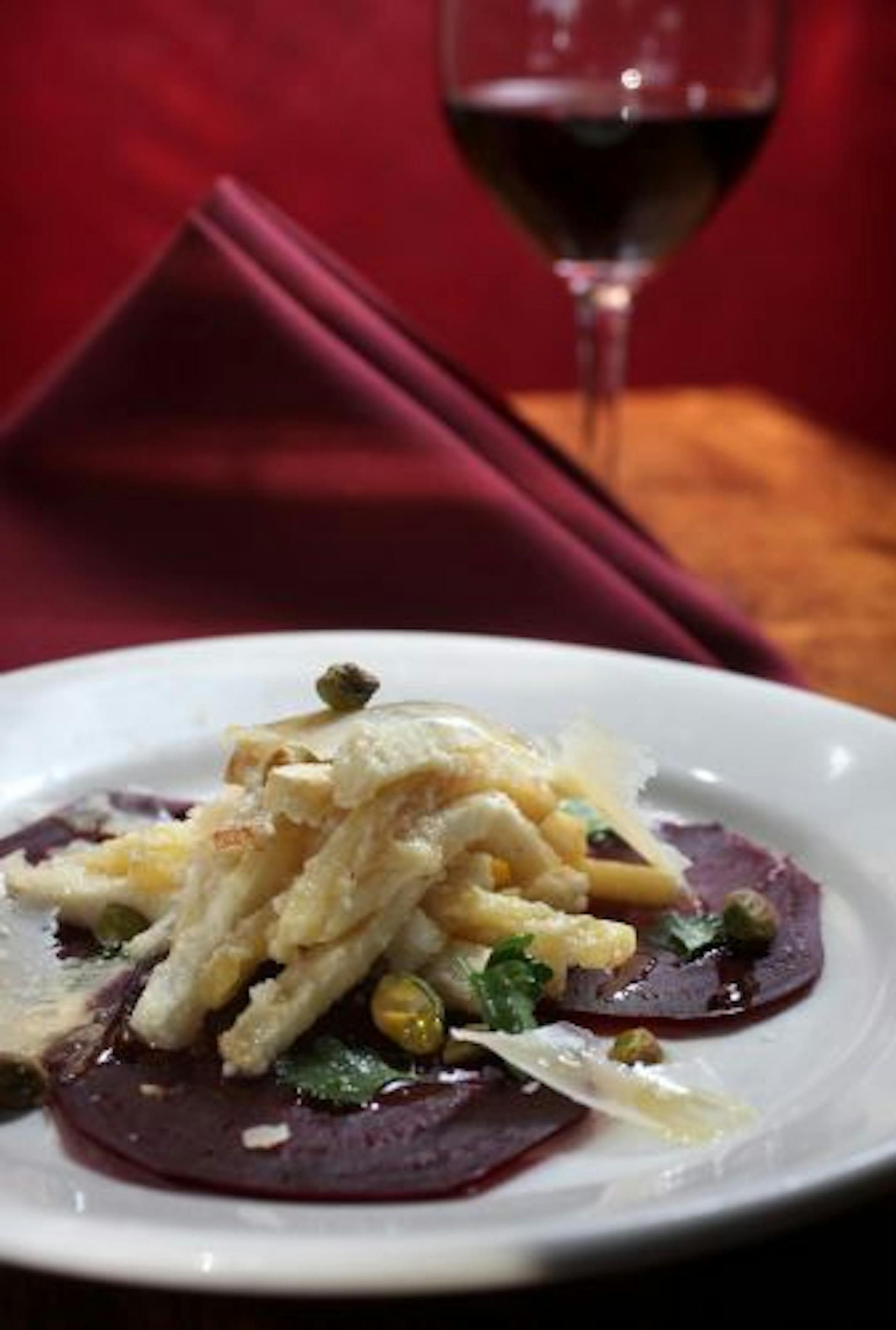 A salad of thin-sliced beets and pistachios is dressed with a Parmesan vinaigrette.