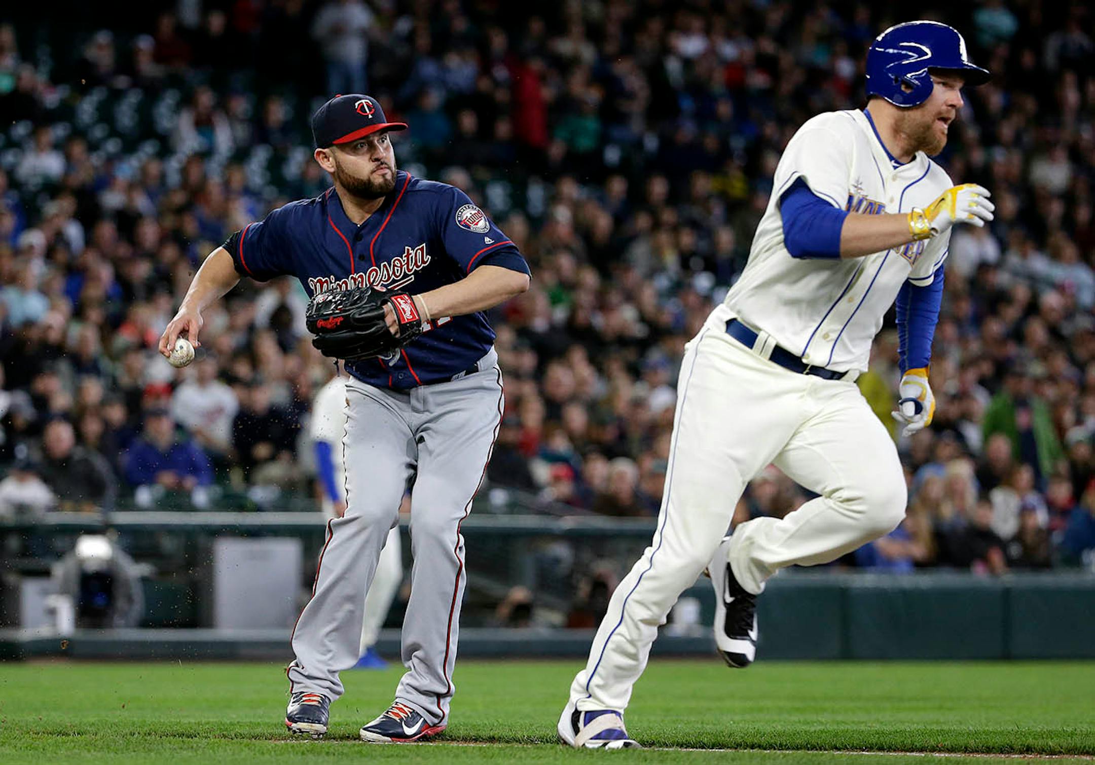 Minnesota Twins starting pitcher Ricky Nolasco, left, readies a throw to first after fielding a ground ball by Seattle Mariners' Adam Lind, right, in the second inning of a baseball game Sunday, May 29, 2016, in Seattle. Lind was out on the play.