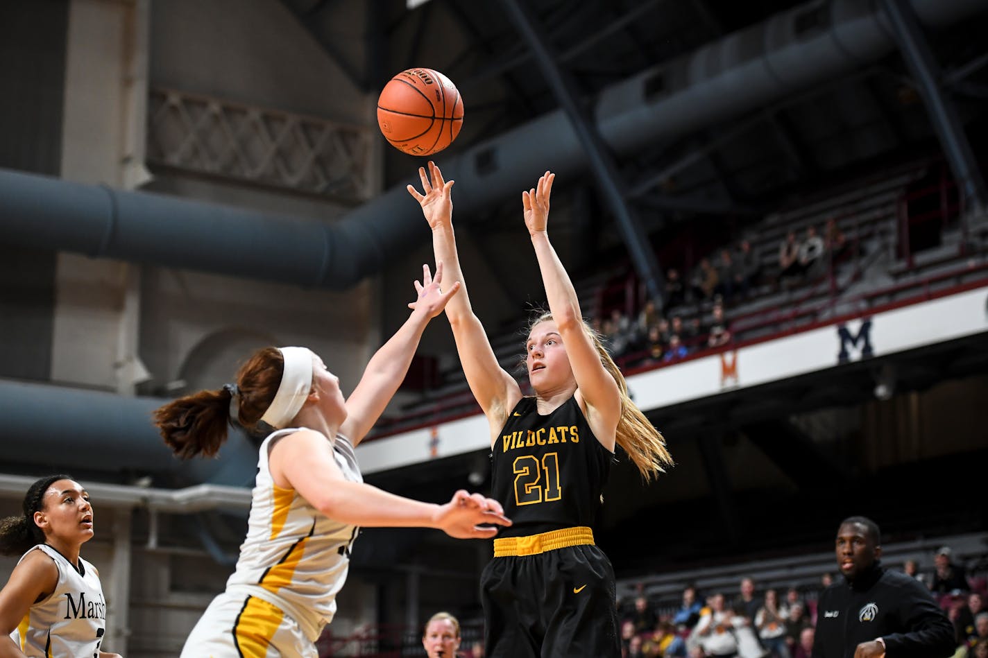 New London-Spicer forward Emma Hanson (21) hit a basket as she was defended by Duluth Marshall forward Laila Monroe (15) in the first half.