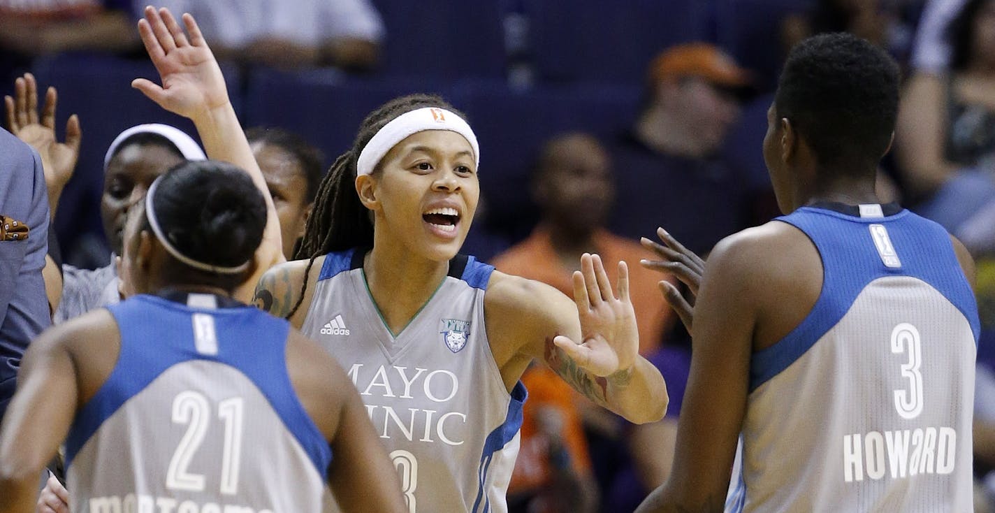 Minnesota Lynx's Seimone Augustus, middle, celebrates with Renee Montgomery (21) and Natasha Howard (3) as the Lynx take an early lead against the Phoenix Mercury during the first half of a WNBA basketball game Wednesday, May 25, 2016, in Phoenix. (AP Photo/Ross D. Franklin)