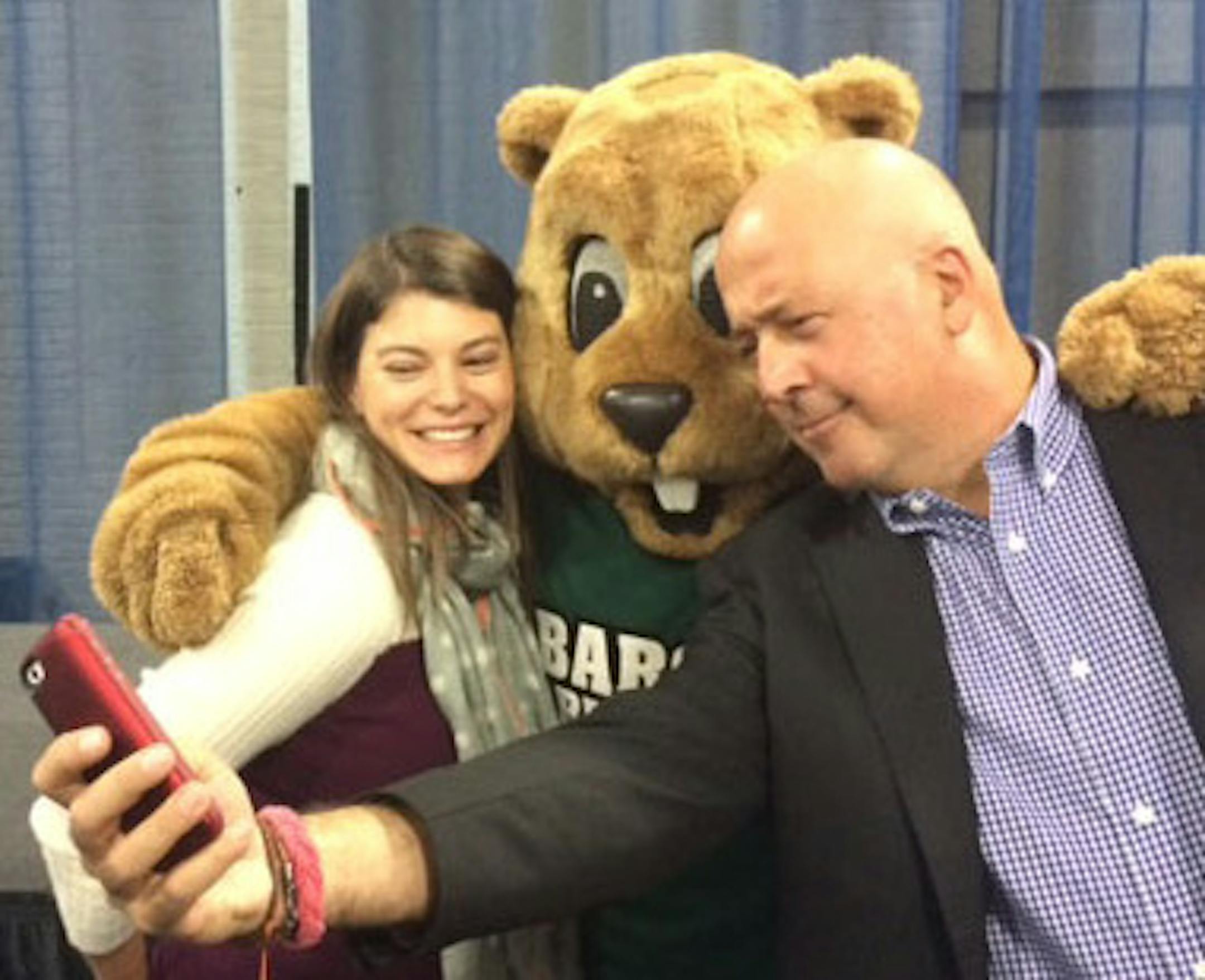Andrew Zimmern in photographed taking a selfie with fans.