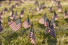 Activists from the COVID Memorial Project mark the deaths of 200,000 lives lost in the U.S. to COVID-19 after placing thousands of small American flag