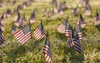 Activists from the COVID Memorial Project mark the deaths of 200,000 lives lost in the U.S. to COVID-19 after placing thousands of small American flag