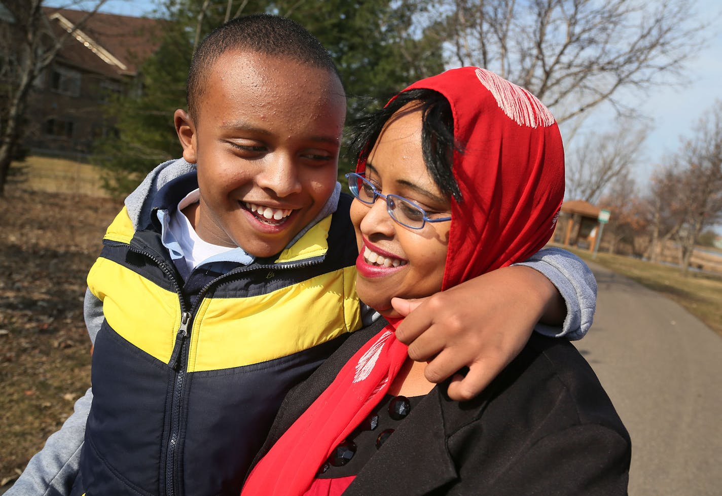 Fierce advocate Idil Abdull walks with her son Abdullahi, 12, at a Burnsville Park near their Savage home Wednesday, April 1, 2015, in Burnsville, MN. Abdullahi is often affectionate towards his mother. Routine, Abdul says, is important in the life of her autistic son, requiring trips to Wendy's for french fries over spring break and walks that go to familiar places and and in familiar directions.](DAVID JOLES/STARTRIBINE)djoles@startribune.com Idil Abdull, a relentless advocate for expanded aut