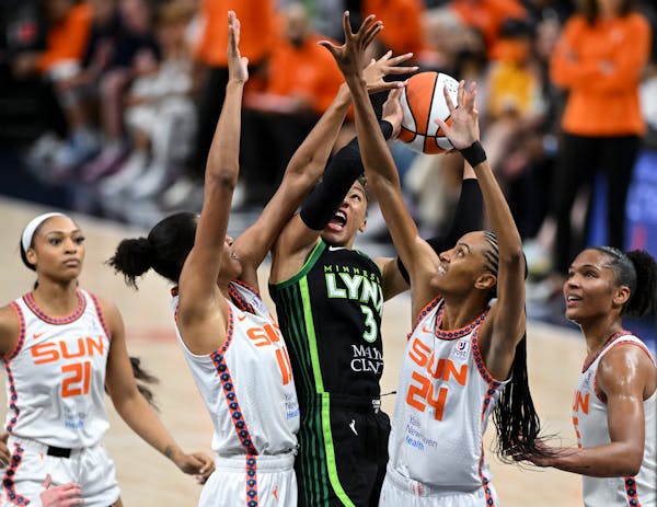 Minnesota Lynx guard Aerial Powers (3) is denied a basket as she's defended by Connecticut Sun forward DeWanna Bonner (24) and center Olivia Nelson-Od