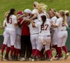 Alabama's Reagan Dykes is mobbed by teammates after her game winning bases-loaded walk against Minnesota in the NCAA regional softball tournament, Sat