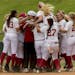 Alabama's Reagan Dykes is mobbed by teammates after her game winning bases-loaded walk against Minnesota in the NCAA regional softball tournament, Sat