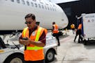 In this July 12, 2016, photo, Delta Air Lines employee Victor Da Rosa checks a baggage scanner before unloading baggage from a flight at Baltimore-Was
