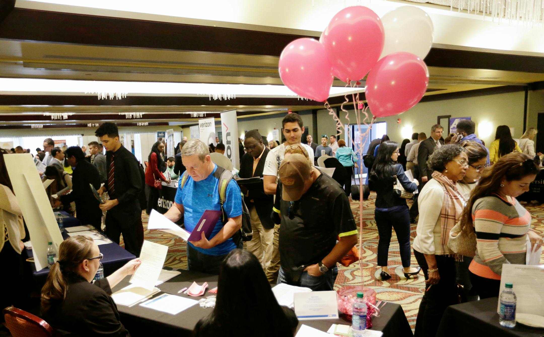 FILE- In this Jan. 30, 2018, file photo, job applicants talk with employees of Hialeah Park, at a JobNewsUSA job fair in Miami Lakes, Fla. On Friday, May 4, the U.S. government issues the April jobs report. (AP Photo/Lynne Sladky, File)