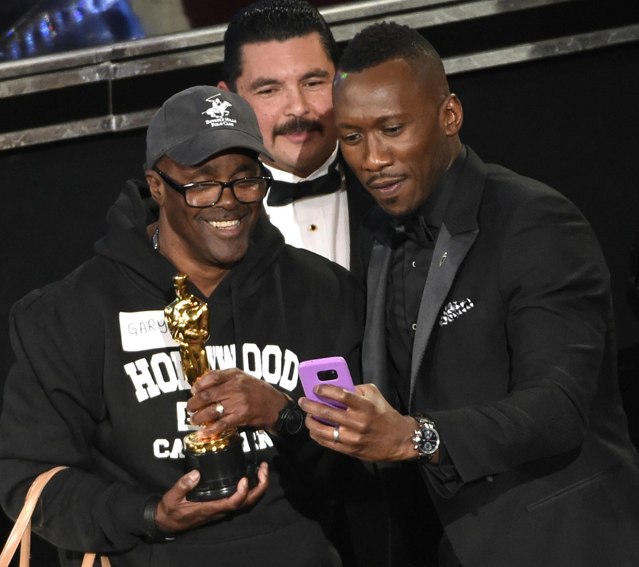Mahershala Ali, right, takes a selfie with a tourist named Gary while holding his award for best actor in a supporting role for "Moonlight" at the Oscars on Sunday, Feb. 26, 2017, at the Dolby Theatre in Los Angeles. (Photo by Chris Pizzello/Invision/AP)