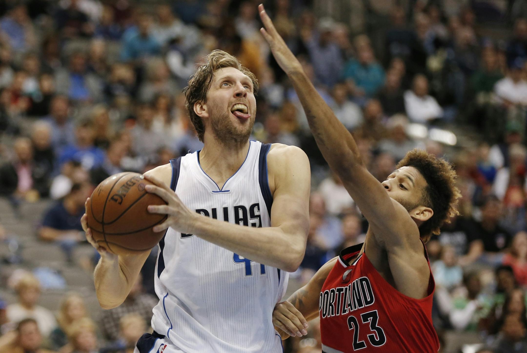 Dallas Mavericks forward Dirk Nowitzki (41) battles Portland Trail Blazers guard Allen Crabbe (23) for space during the second half of an NBA basketball game Sunday March 20, 2016, in Dallas. (AP Photo/Brandon Wade)