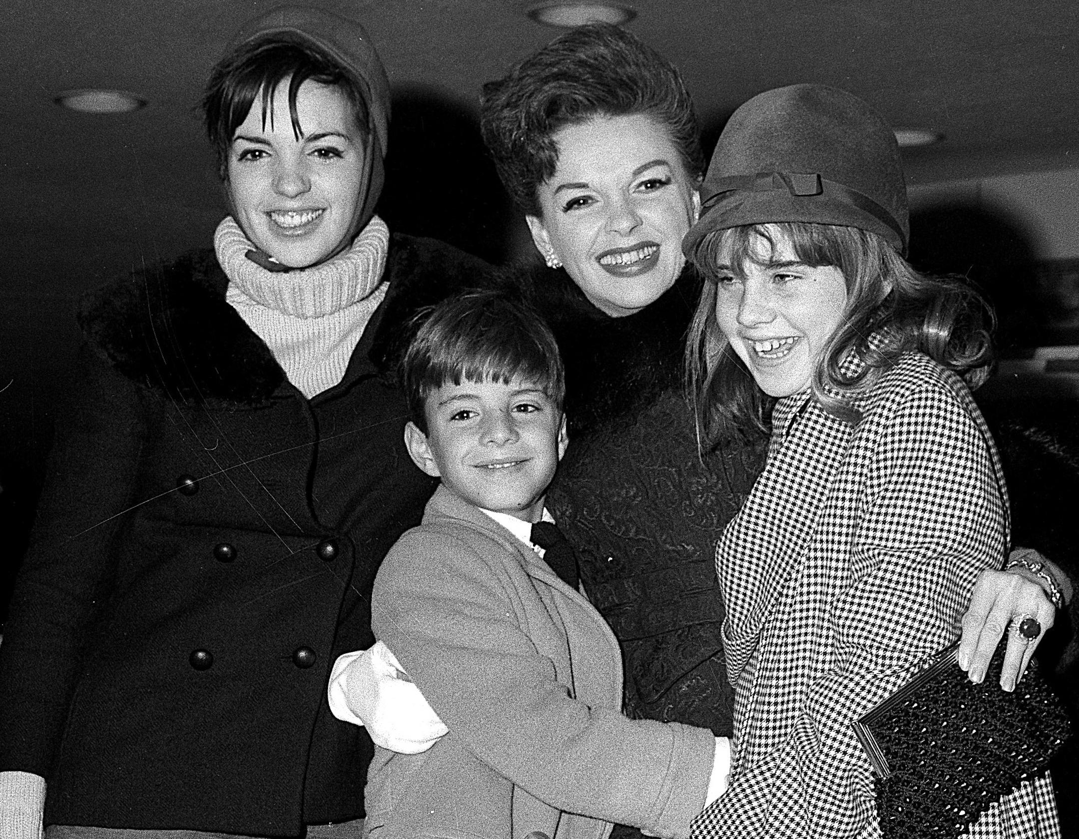 FILE - In this Dec. 29, 1964 file photo, singer-actress Judy Garland greets her son Joseph, 9, and daughter Lorna, 12, after they arrive from California at New York's Kennedy International Airport, in New York. Garland's elder daughter Liza Minnelli poses with them at left. Judy Garland has been laid to rest in a mausoleum named for her at Hollywood Forever Cemetery. A spokeswoman for Garland’s estate has said her family and friends held a private memorial service for the late actress on
