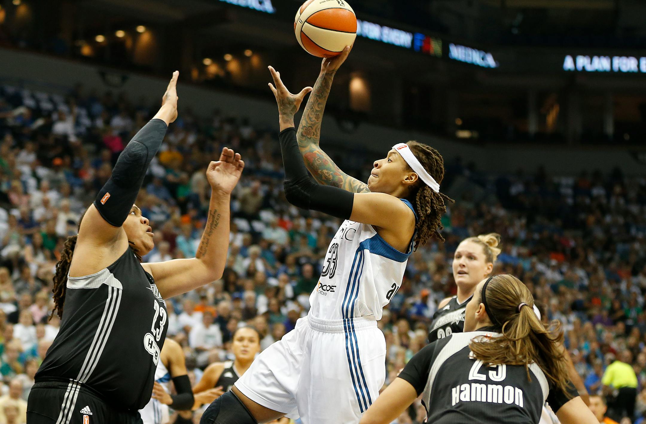 Minnesota Lynx guard Seimone Augustus (33) pushes the ball up to the basket against San Antonio Stars forward Danielle Adams (23) during the first half of Game 1 of a WNBA basketball Western Conference semifinal, Thursday, Aug. 21, 2014, in Minneapolis. (AP Photo/Stacy Bengs)