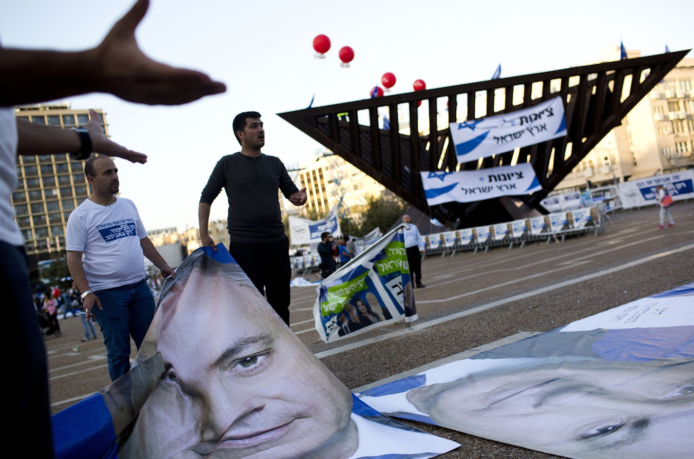 People bring posters of Israeli Prime Minister Benjamin Netanyahu prior to his election rally in Tel Aviv, Israel, Sunday, March 15, 2015, two days ahead of parliament elections. Netanyahu seeks his fourth term as prime minister. (AP Photo/Oded Balilty) ORG XMIT: MIN2015031612490650