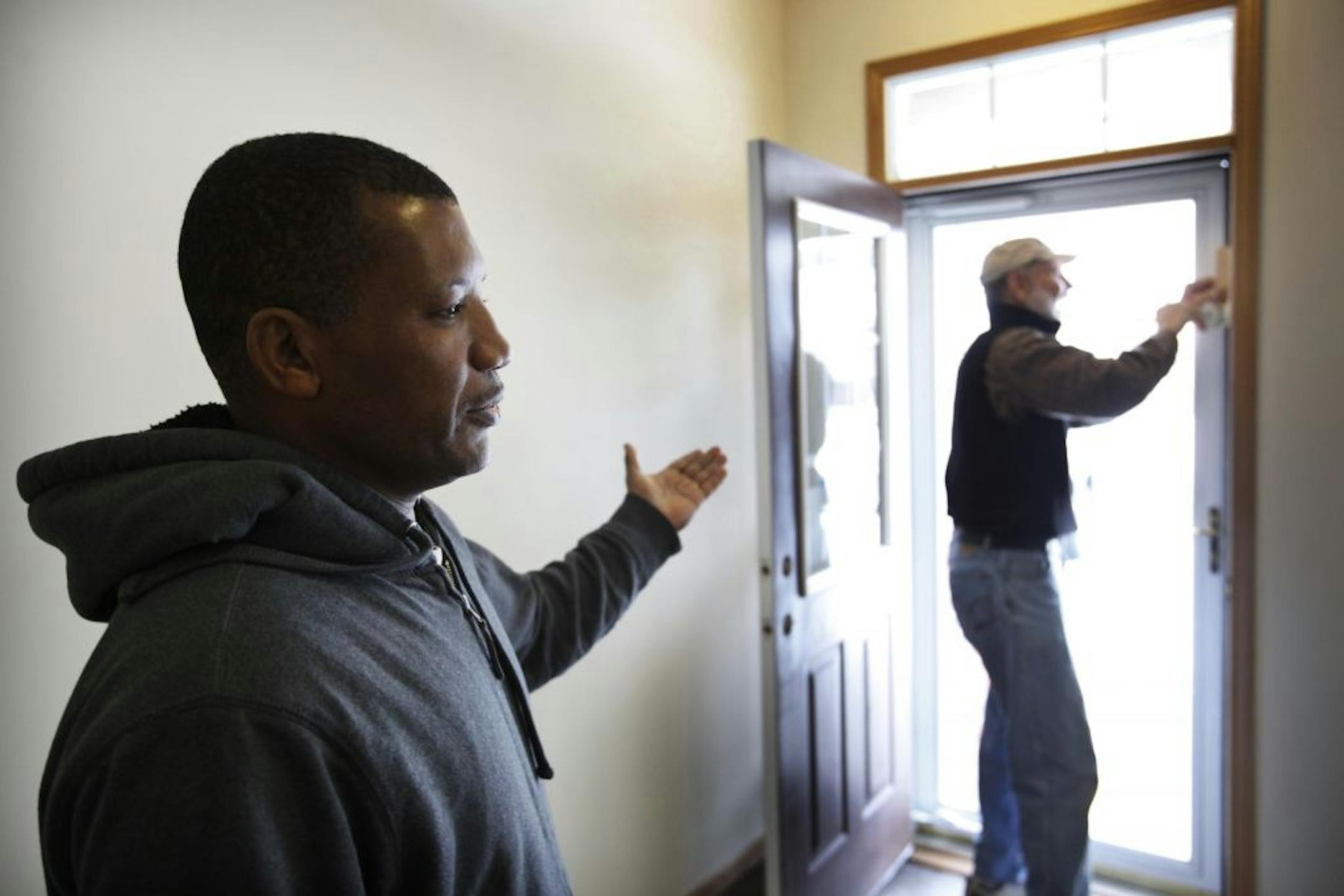 Asregdew Agonafer, left, will be moving into a newly renovated two-bedroom at Garden Gate development with his daughter Redeit, 14. Agonafer, seen next to Habitat volunteer Jerry Swanson, who was painting door trim, was photographed Tuesday, Feb. 21, 2012, in Woodbury, MN.