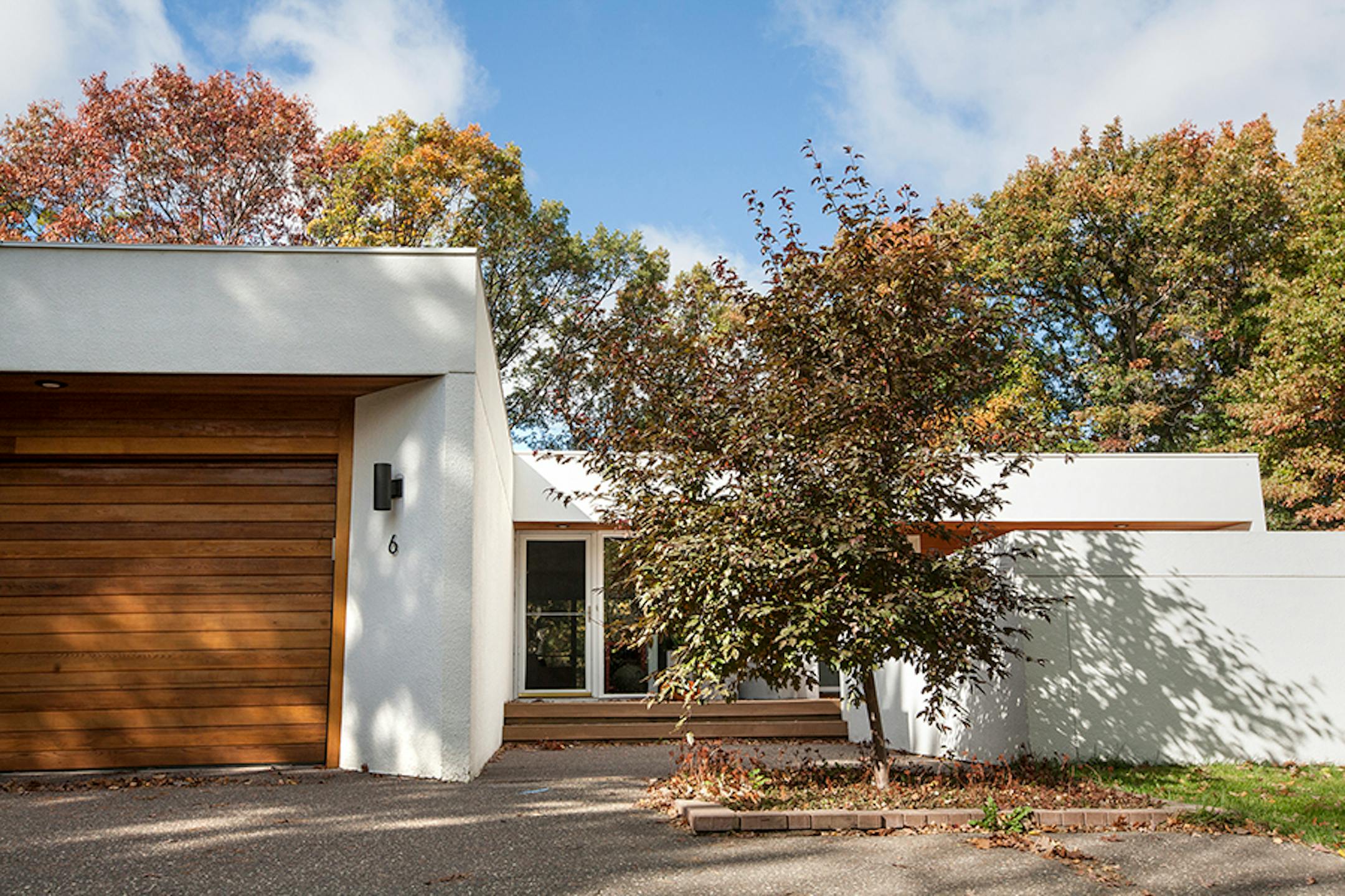A front exterior of he 1972 mid-century modern home in North Oaks. The homeowners retouched the exterior stucco and added cedar siding accents.