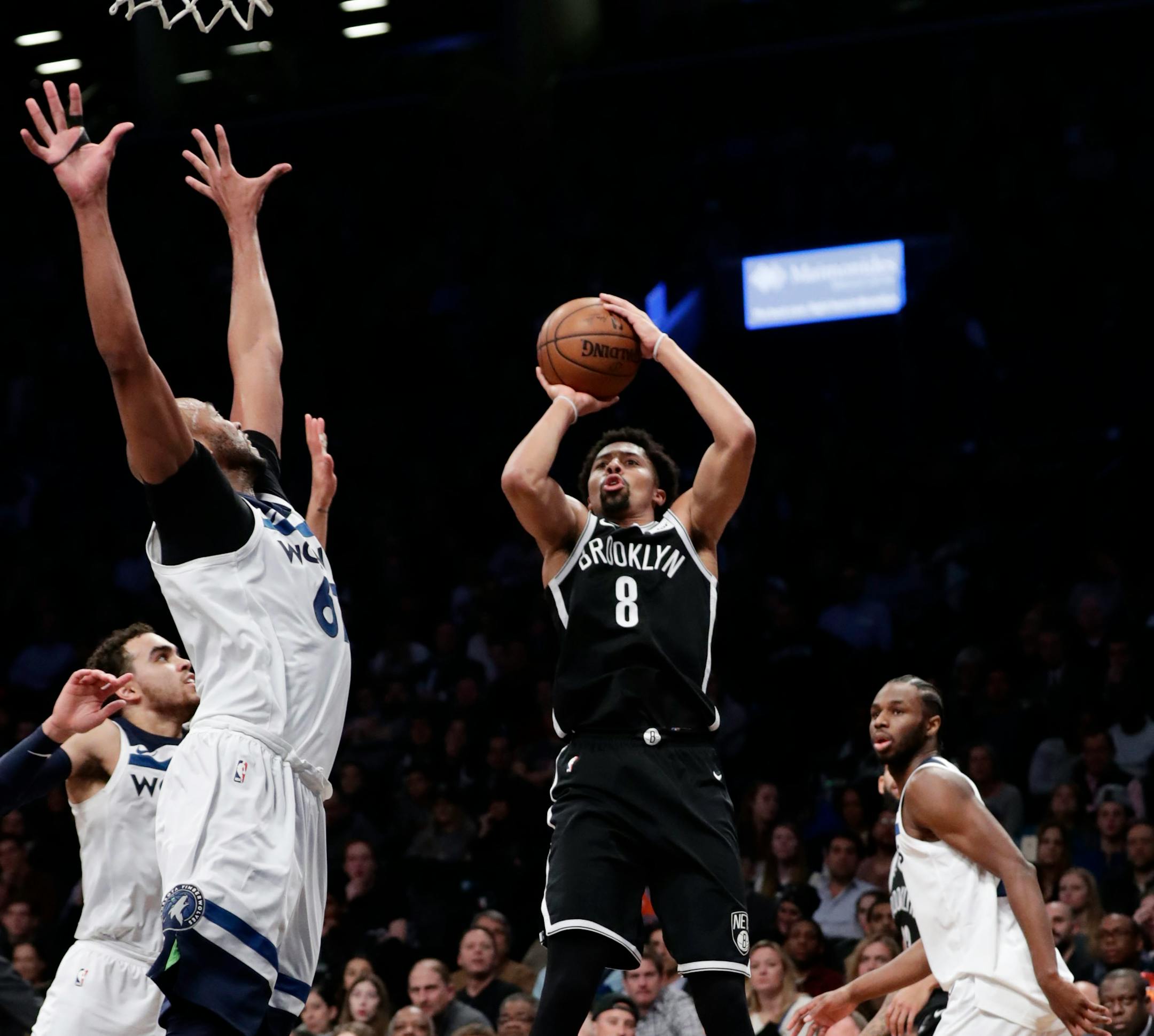 Brooklyn Nets' Spencer Dinwiddie (8) shoots over Minnesota Timberwolves' Taj Gibson, left, and Andrew Wiggins, right, during the second half of an NBA basketball game Wednesday, Jan. 3, 2018, in New York. The Nets won 98-97. (AP Photo/Frank Franklin II)