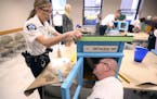 Police inspectors Kathy Waite and Mike Sullivan assembled a Little Free Library at City Hall on Tuesday. The boxes will be placed inside precincts.