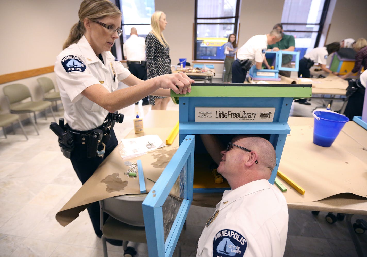 Police inspectors Kathy Waite and Mike Sullivan assembled a Little Free Library at City Hall on Tuesday. The boxes will be placed inside precincts.