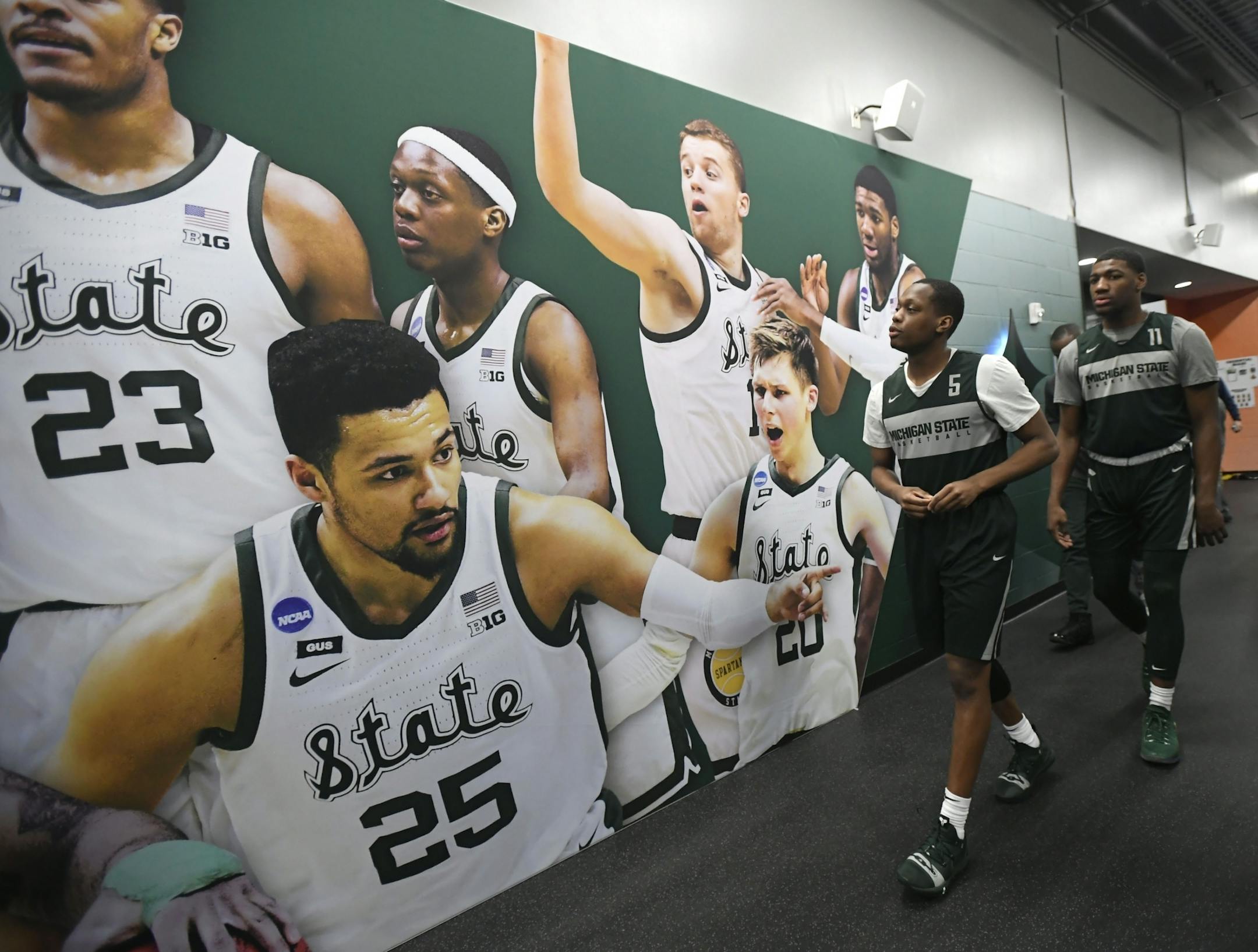 Michigan State guard Cassius Winston (5) and Michigan State forward Aaron Henry (11) admired their team display in the hallway on the way to practice.