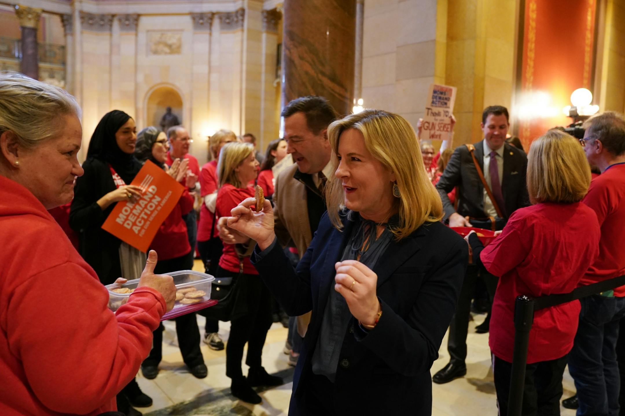 House Speaker Melissa Hortman grabbed a cooke from the Moms Demand Action organizers as they waited to greet state house representatives before the start of the legislative session Tuesday.