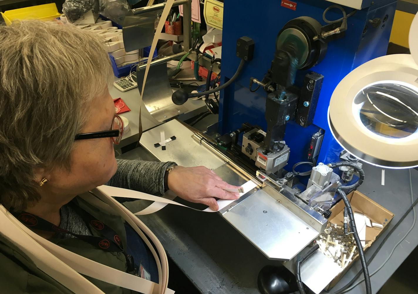 A worker at Digi-Key stitches connectors onto a length of tape.