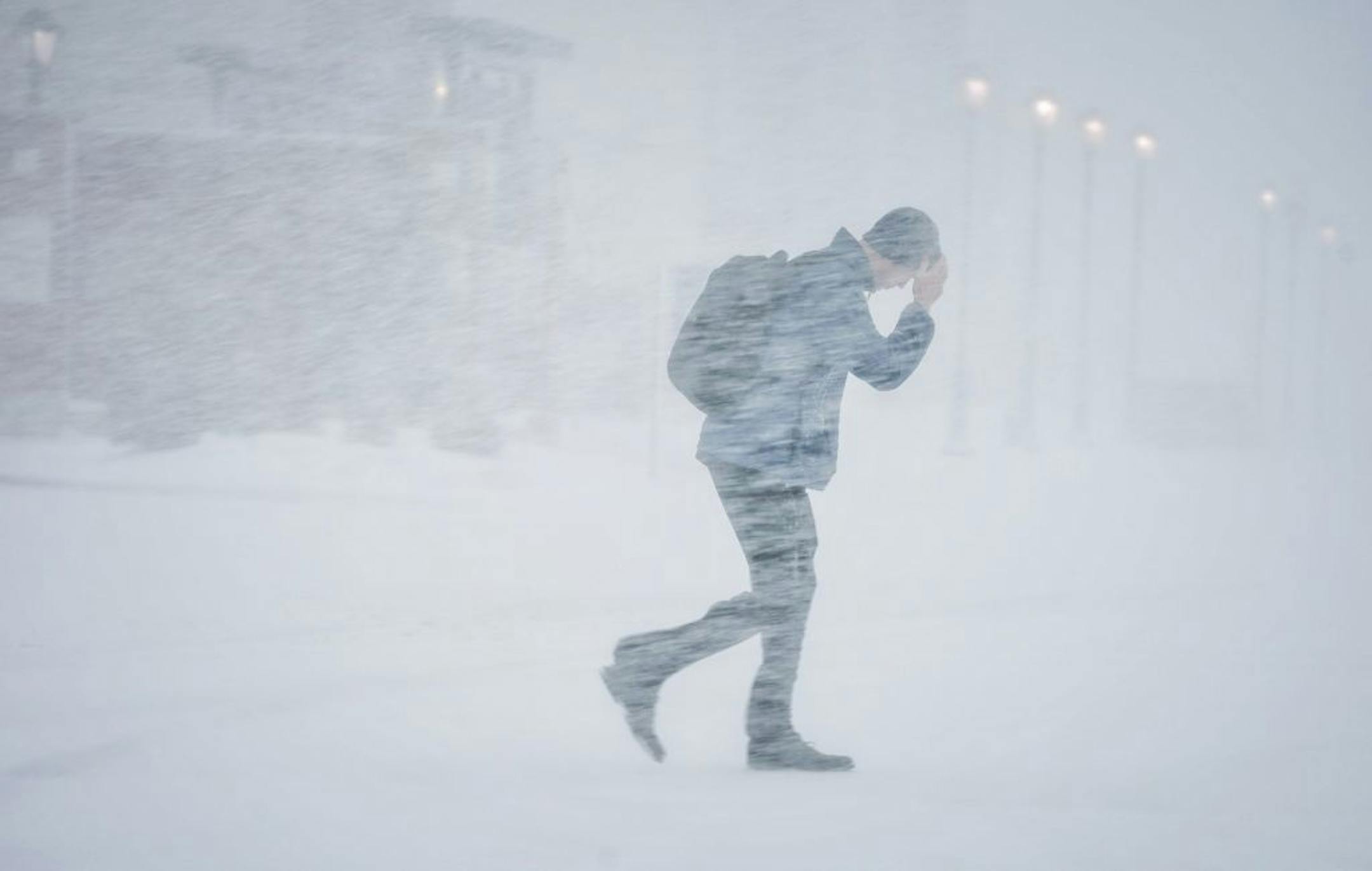 Customers tried to protect themselves from blowing snow in the parking lot of the Twin Cities Premium Outlets in Eagan.