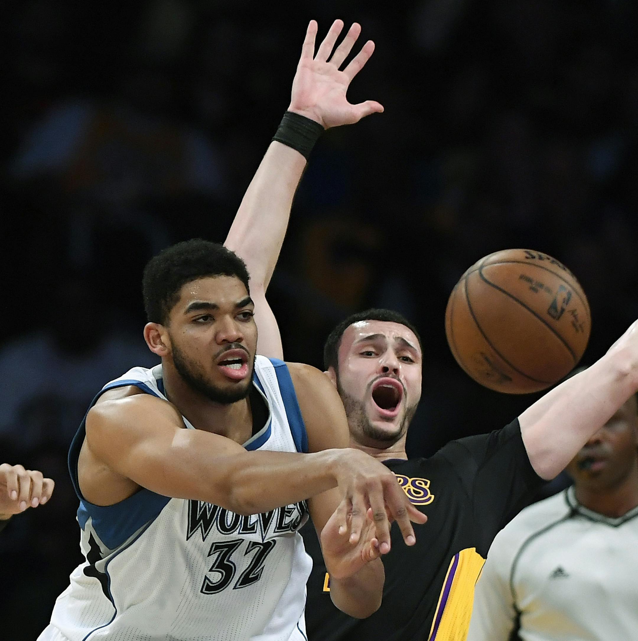 Minnesota Timberwolves center Karl-Anthony Towns, left, passes the ball as Los Angeles Lakers forward Larry Nance Jr. defends during the first half of an NBA basketball game, Friday, March 24, 2017, in Los Angeles. (AP Photo/Mark J. Terrill)