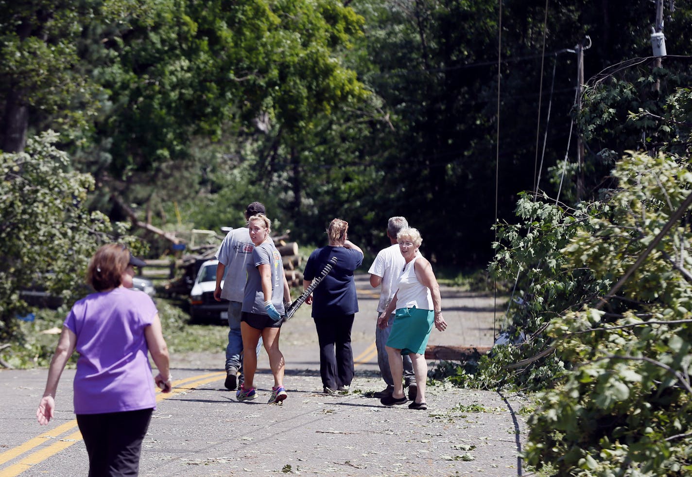 Neighbors checked out the storm damage along Ojibwa Road on North Long Lake Monday in Brainerd, Minn.