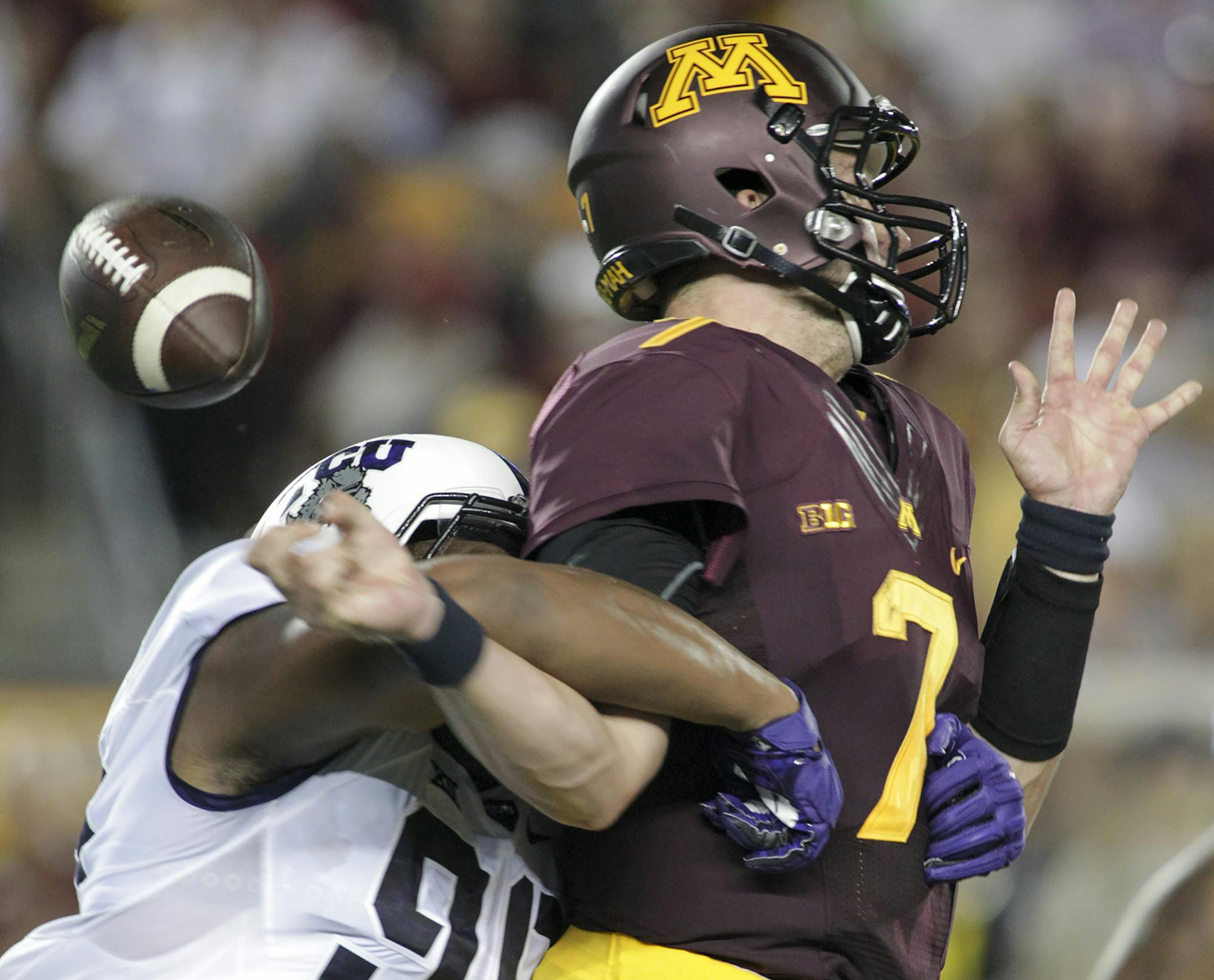 Minnesota quarterback Mitch Leidner (7) is stripped of the ball by TCU defensive end Terrell Lathan (90) during the first half of an NCAA college football game Thursday, Sept. 3, 2015, in Minneapolis. (AP Photo/Paul Battaglia)
