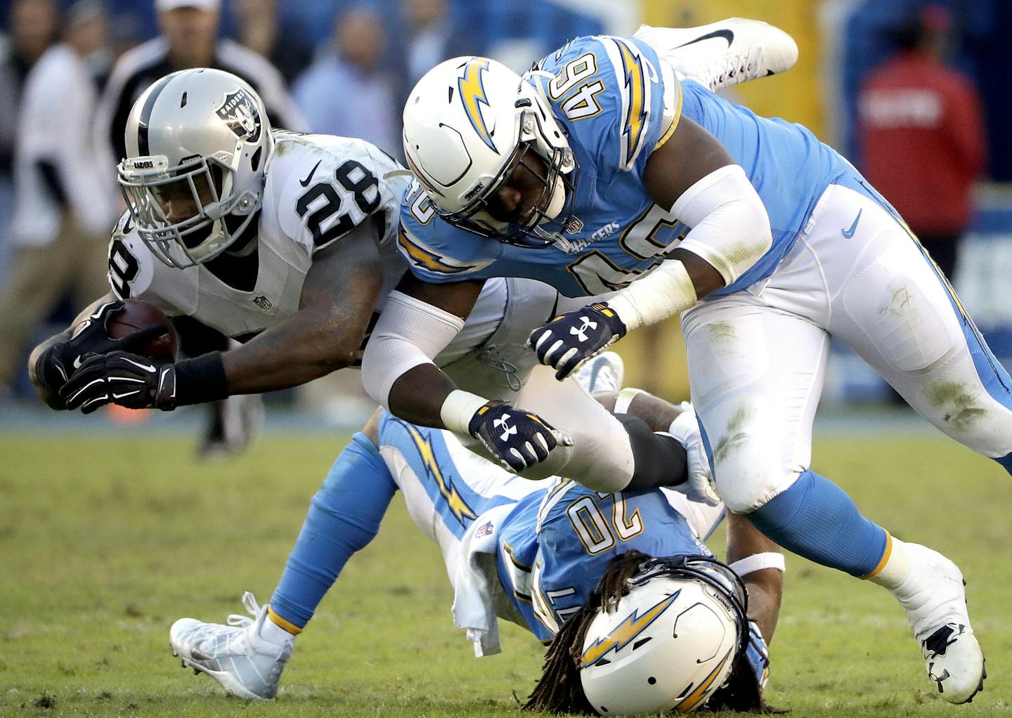 Oakland Raiders running back Latavius Murray (28) is stopped by San Diego Chargers safety Dwight Lowery (20) and linebacker Chris Landrum (46) during the second half of an NFL football game Sunday, Dec. 18, 2016, in San Diego. (AP Photo/Alex Gallardo) ORG XMIT: OTKAG