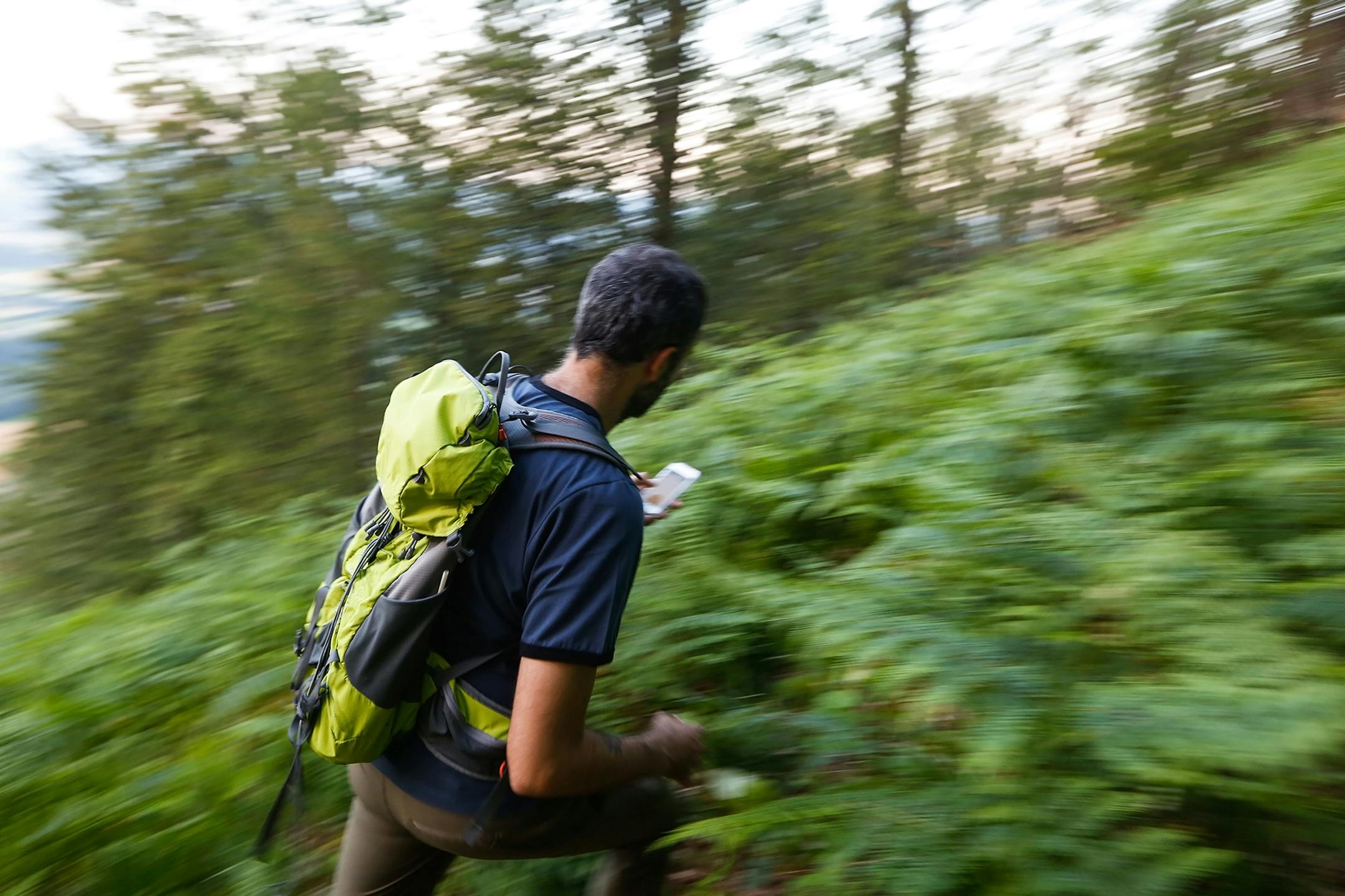 Hiker searching cache using global positioning device.