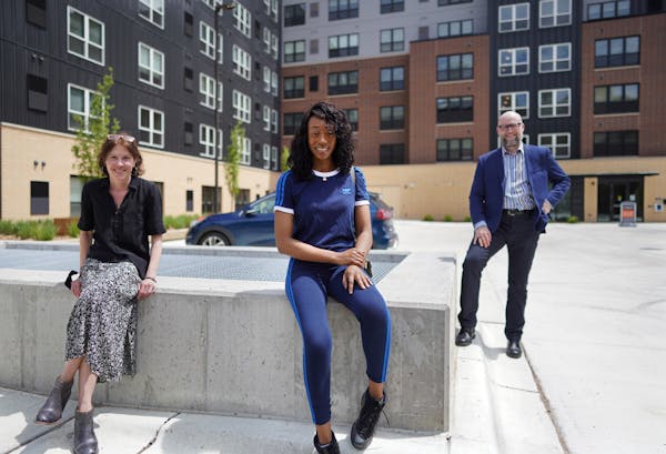 Elizabeth Flannery of Community Housing Development Corp., Rheasa Otto and the Rev. Dan Collison, outside East Town Apartments in downtown Minneapolis