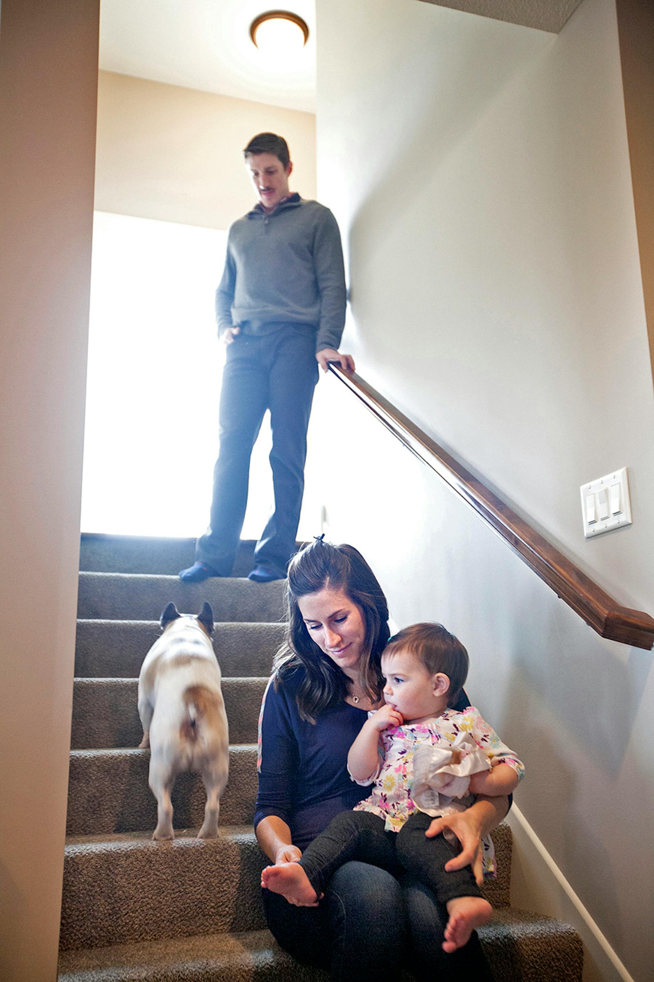 Minnesota Wild's Ryan Carter comes downstairs to play with daughters as his wife Erin holds their youngest, Natalie, 15 months, at their home in Gem Lake November 22, 2015.
