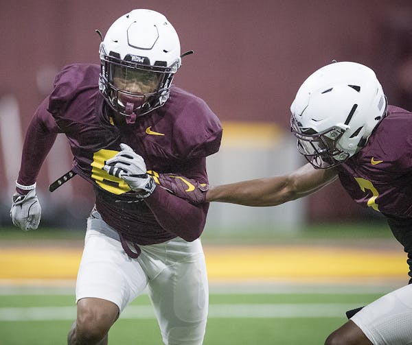 Minnesota's defensive back Chris Williamson, left, took to the field for the first practice that was open to the public at the Athletes Village at the