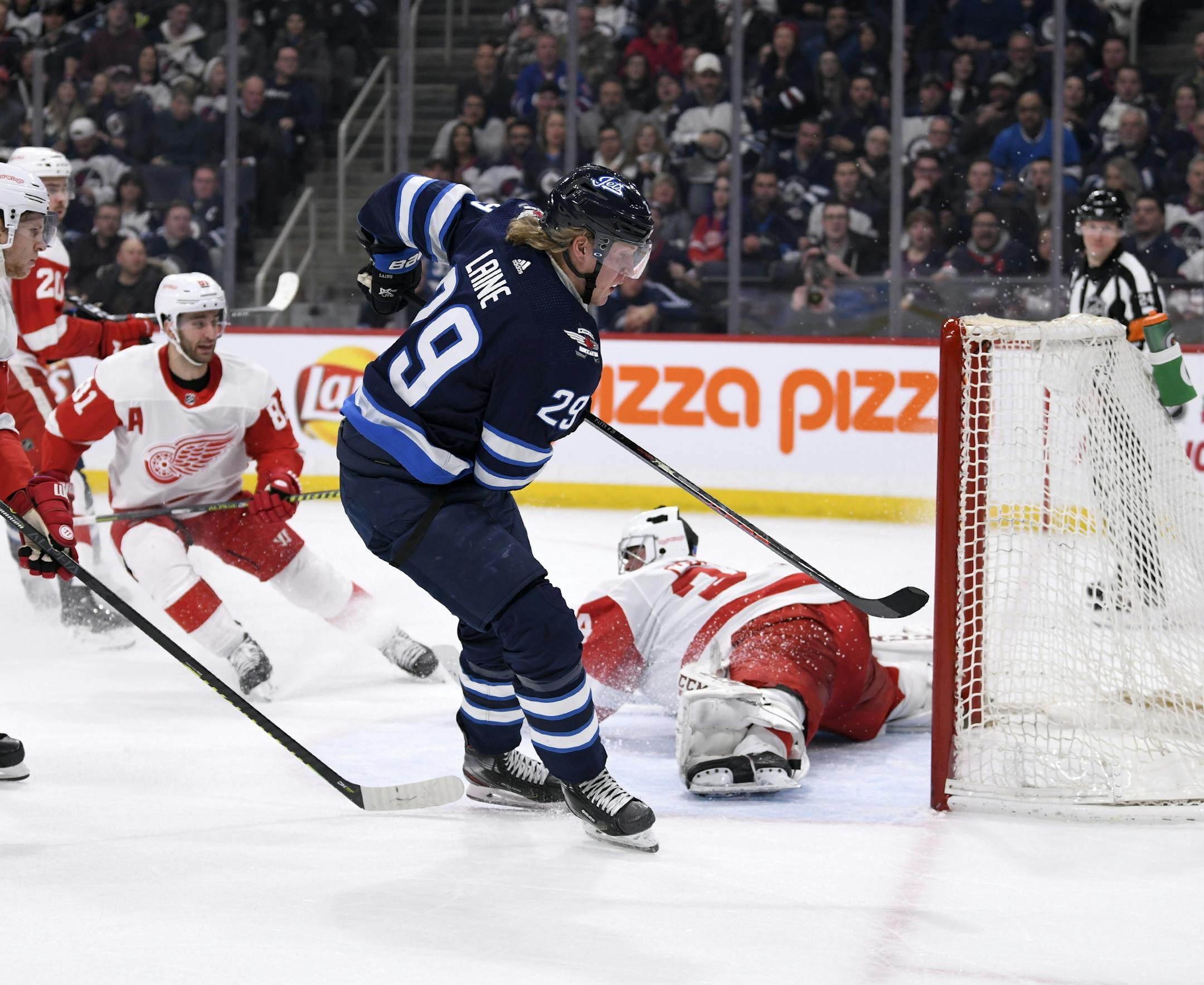 Winnipeg Jets' Patrik Laine (29) scores on Detroit Red Wings goaltender Eric Comrie (34) during the second period of an NHL hockey game, Tuesday, Dec. 10, 2019, in Winnipeg, Manitoba. (Fred Greenslade/The Canadian Press via AP)