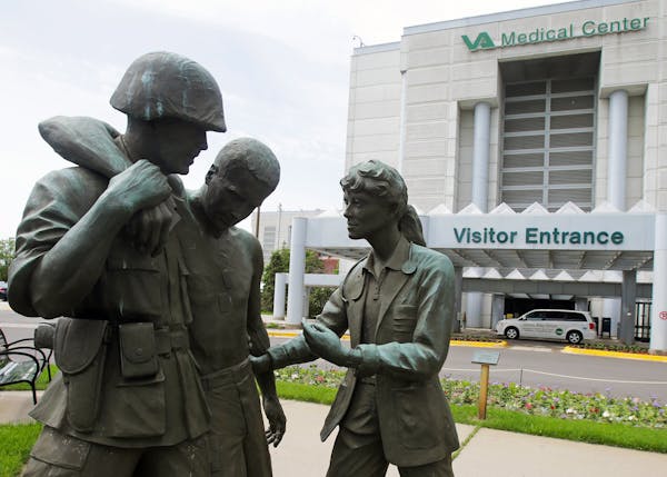 FILE - In this June 9, 2014 file photo is a sculpture portraying a wounded soldier being helped on the grounds of the Minneapolis VA Hospital. Minneso