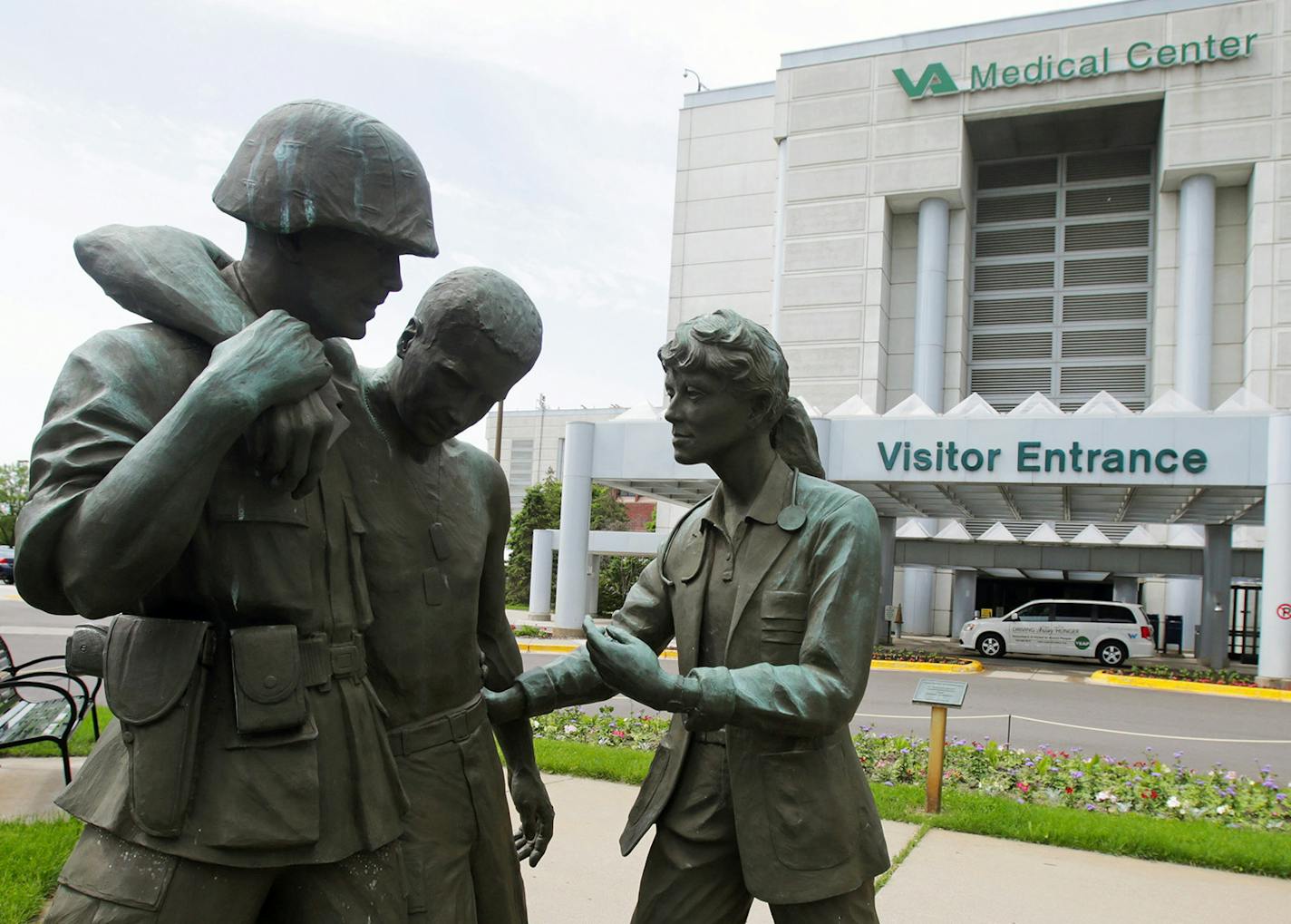 FILE - In this June 9, 2014 file photo is a sculpture portraying a wounded soldier being helped on the grounds of the Minneapolis VA Hospital. Minnesota&#xed;s Veterans Affairs clinics and hospitals fare slightly better in delivering timely care to veterans than the national average between September and February, according to six months of appointment data analyzed by the Associated Press. (AP Photo/Jim Mone, File) ORG XMIT: MIN2015051314130372