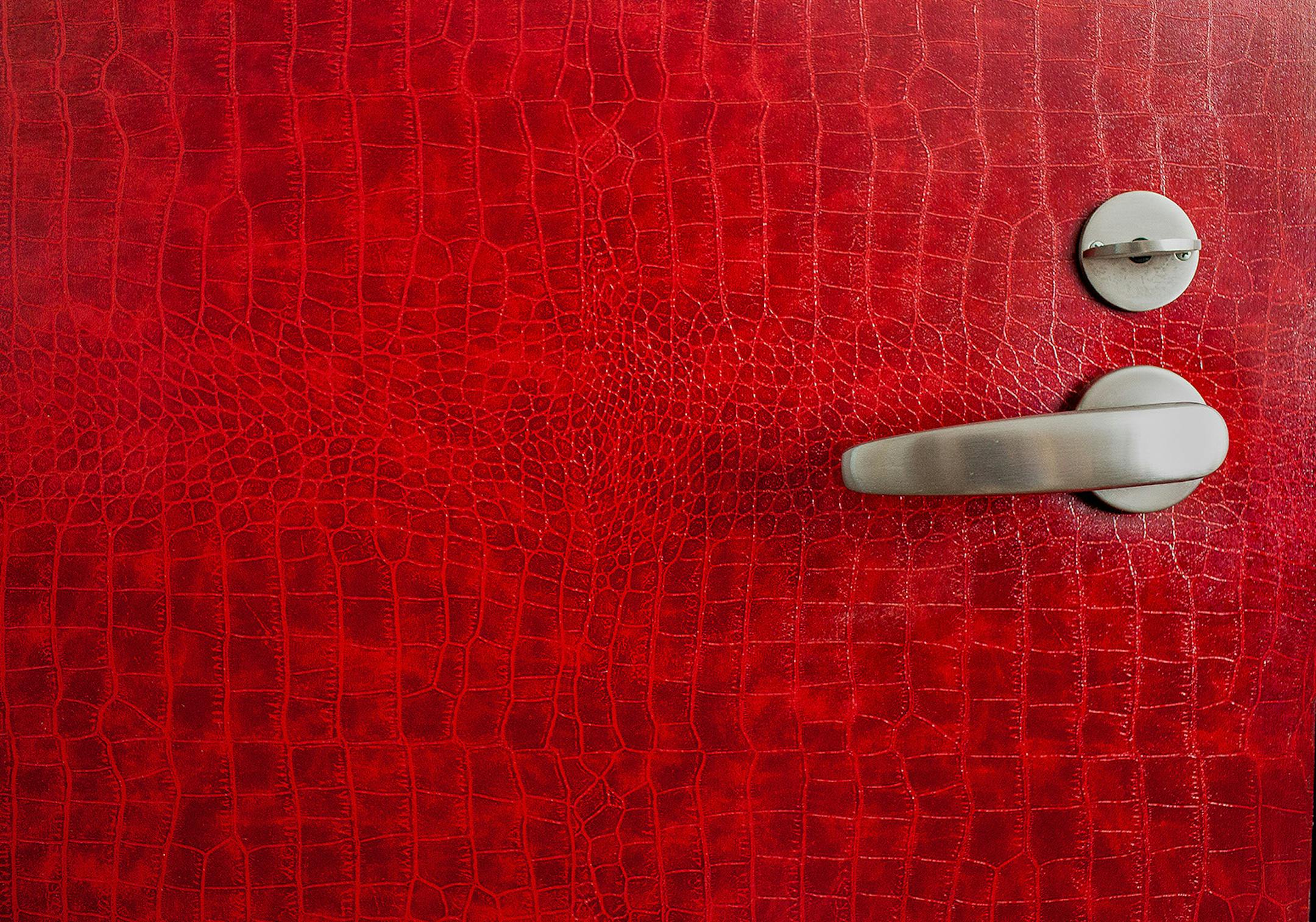 Recycled leather from EcoDomo, embossed in a crocodile design, is used to cover a door.