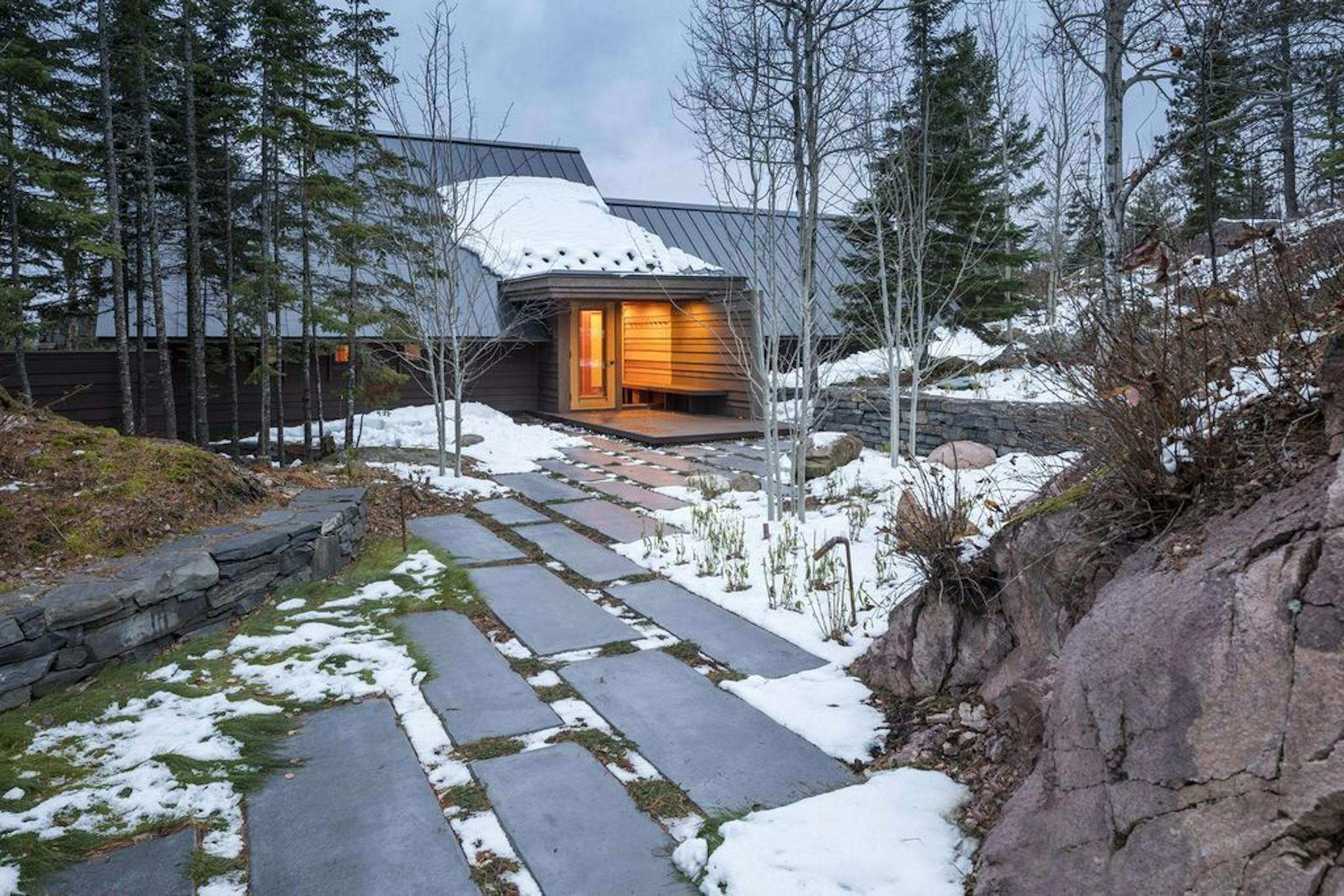 Steeply sloped metal roof on the entry side of the cabin designed for privacy and shelter.