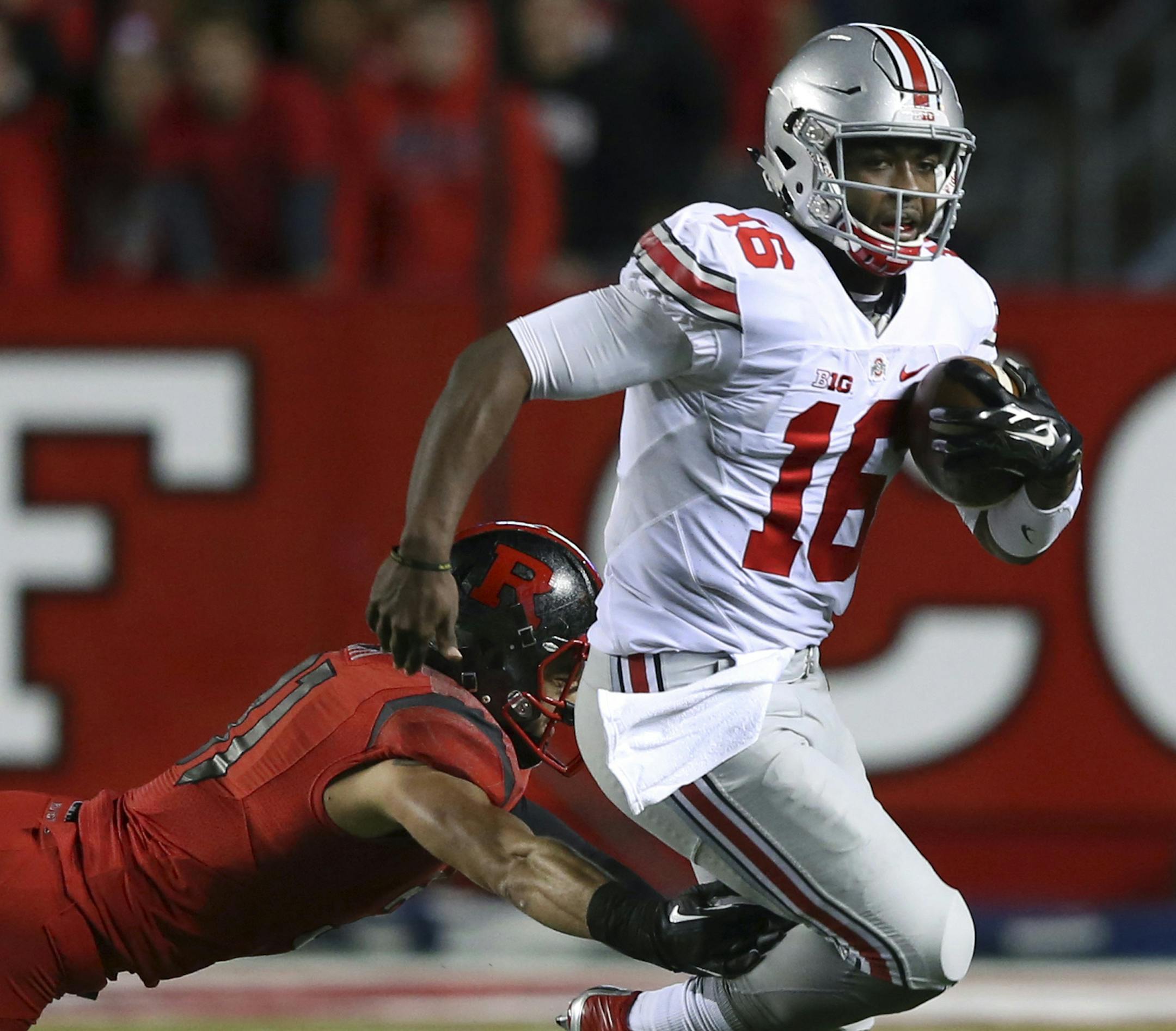 Ohio State quarterback J.T. Barrett (16) breaks a tackle by Rutgers defensive back Anthony Cioffi (31) during the first half of an NCAA college football game Saturday, Oct. 24, 2015, in Piscataway, N.J. (AP Photo/Mel Evans)