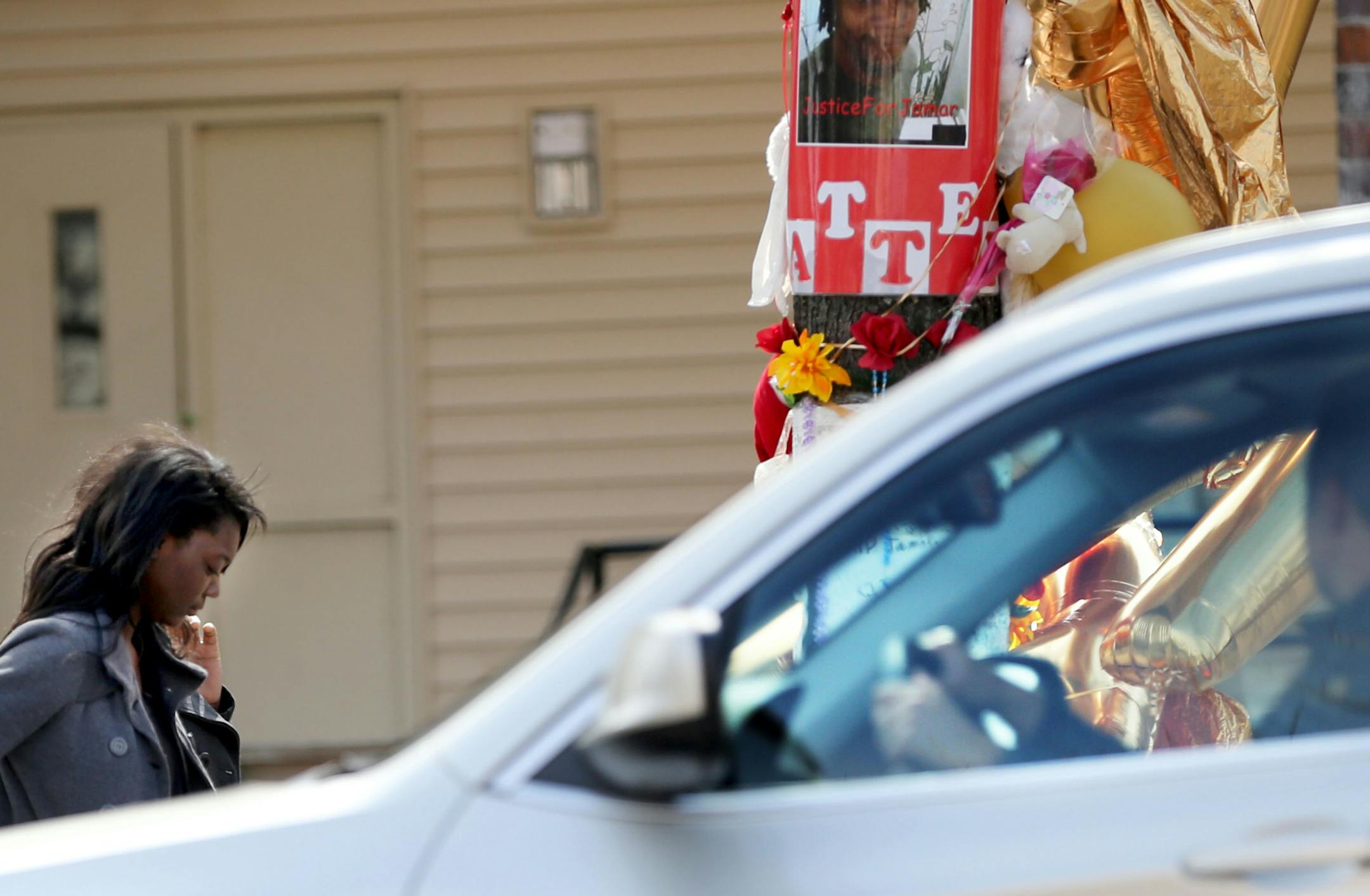 A day after Hennepin County DA Mike Freeman decided not to charge two police officers in the shooting of Jamar Clark in November, Clark's niece Ecirahs Burns visits the his memorial site on Plymouth Ave. N as a passing motorist looks on Thursday, March 31, 2016, in Minneapolis, MN. Burns said the pain of Jamar's death is deep and that the family is working hard to heal. "I want to talk so people know how we feel," Burns said.](DAVID JOLES/STARTRIBUNE)djoles@startribune.com The day after coverage