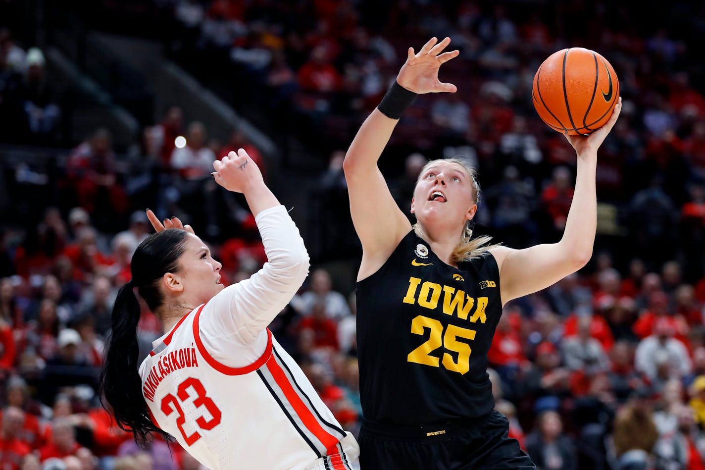 Iowa forward Monika Czinano, right, looks to shoot over Ohio State forward Rebeka Mikulasikova during the first half of an NCAA college basketball game at Value City Arena in Columbus, Ohio, Monday, Jan. 23, 2023. (AP Photo/Joe Maiorana)