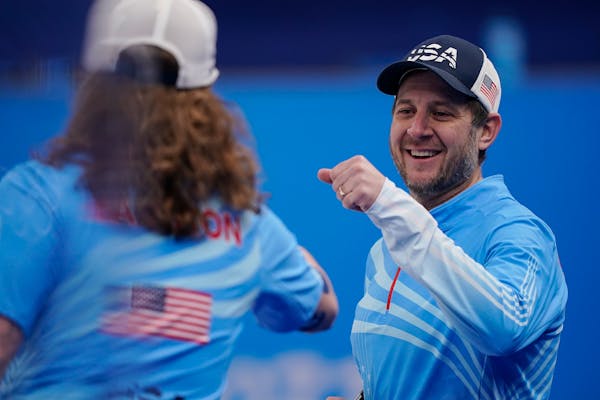 United States' John Shuster celebrates with Matt Hamilton during a men's curling match against Denmark at the Beijing Winter Olympics on Thursday